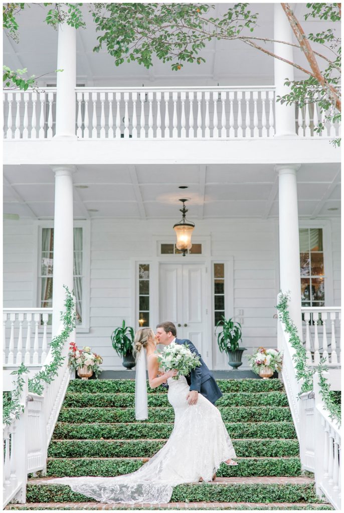 Newlyweds pose for pictures in front of Old Wide Awake, a wedding venue in Charleston, SC