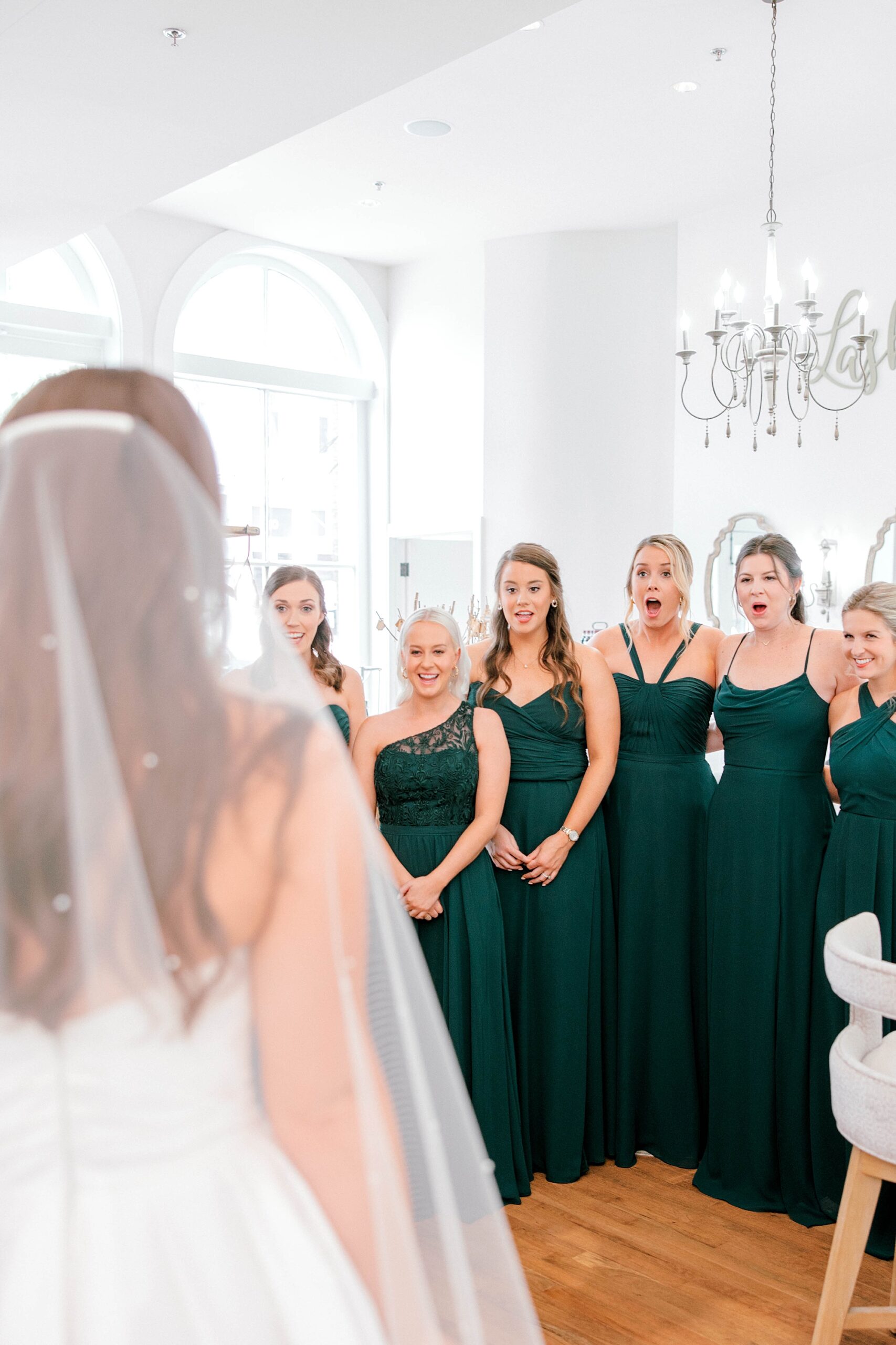 bride has first look with bridesmaids inside Lashes & Lace 