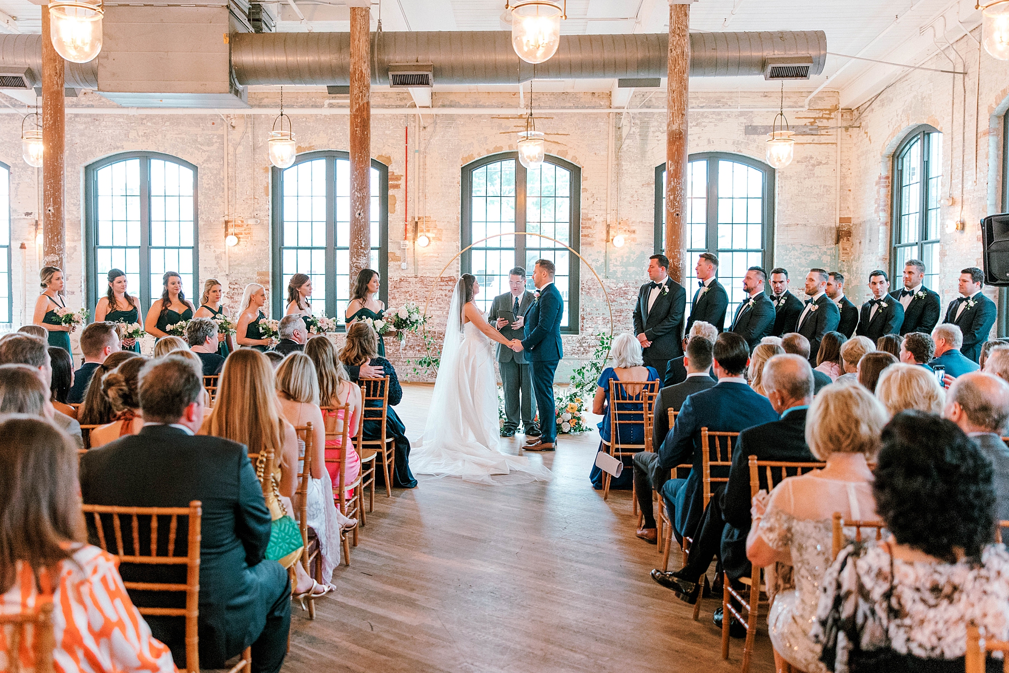 bride and groom hold hands during wedding ceremony inside The Cedar Room
