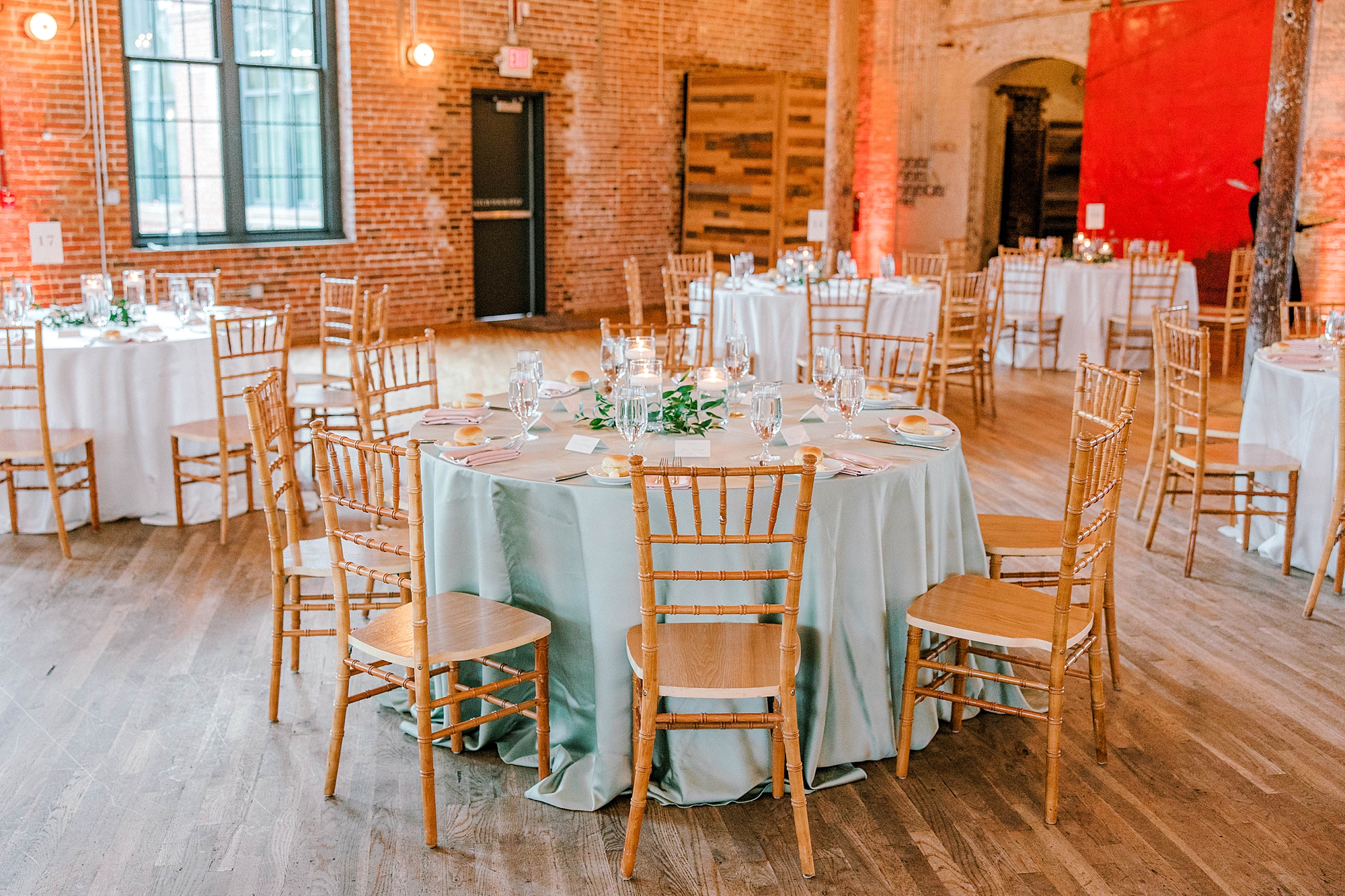 wedding reception inside The Cedar Room with wooden chairs and white table cloths 