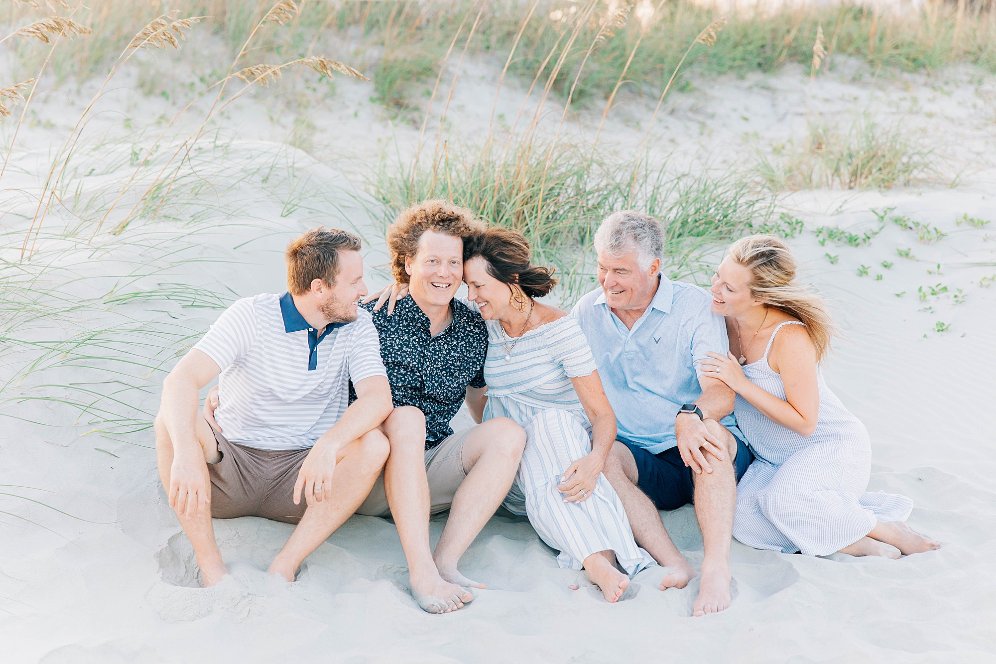 parents laugh with adult children during Charleston beach family photos