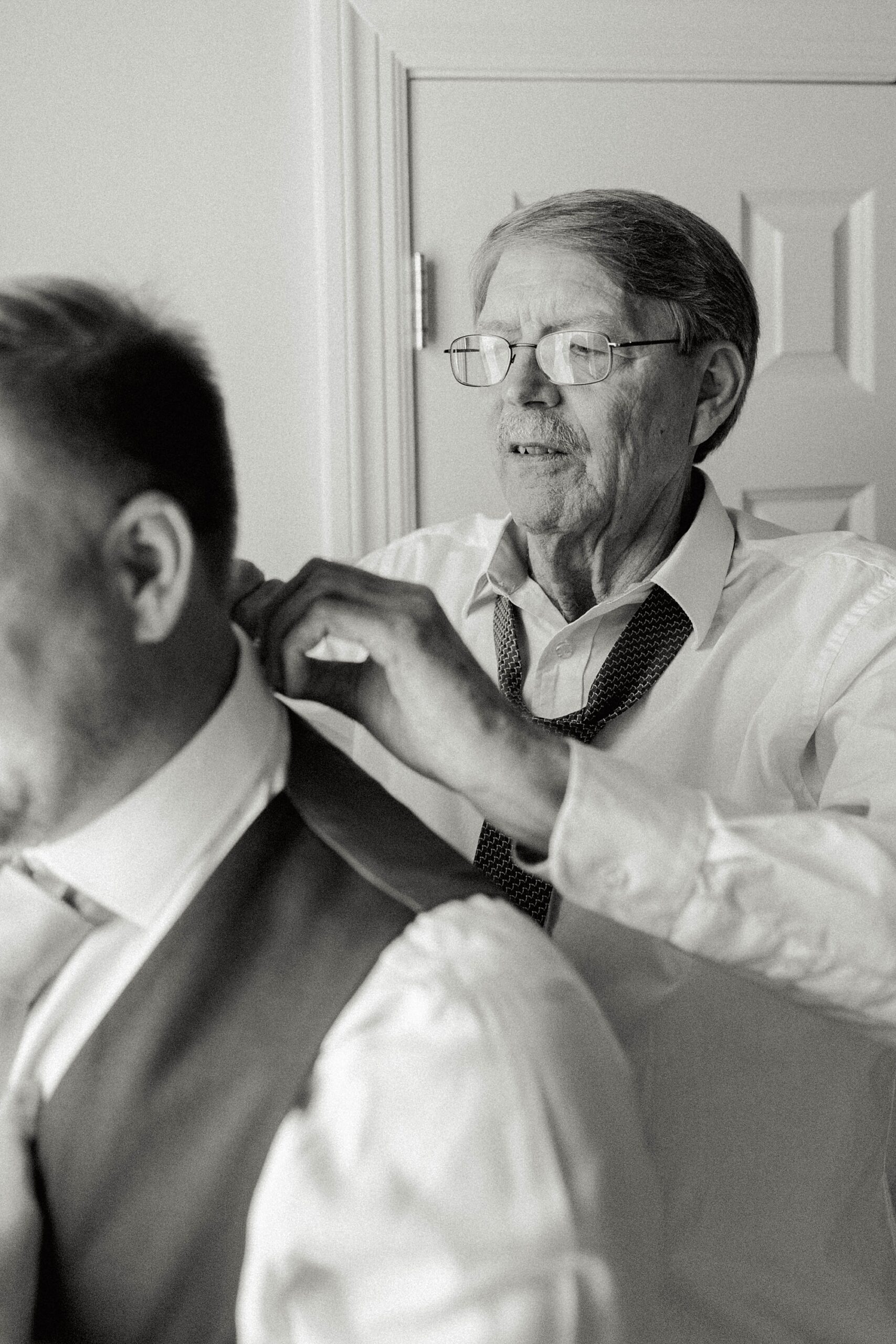 father adjusts tie for groom before wedding in Charleston SC