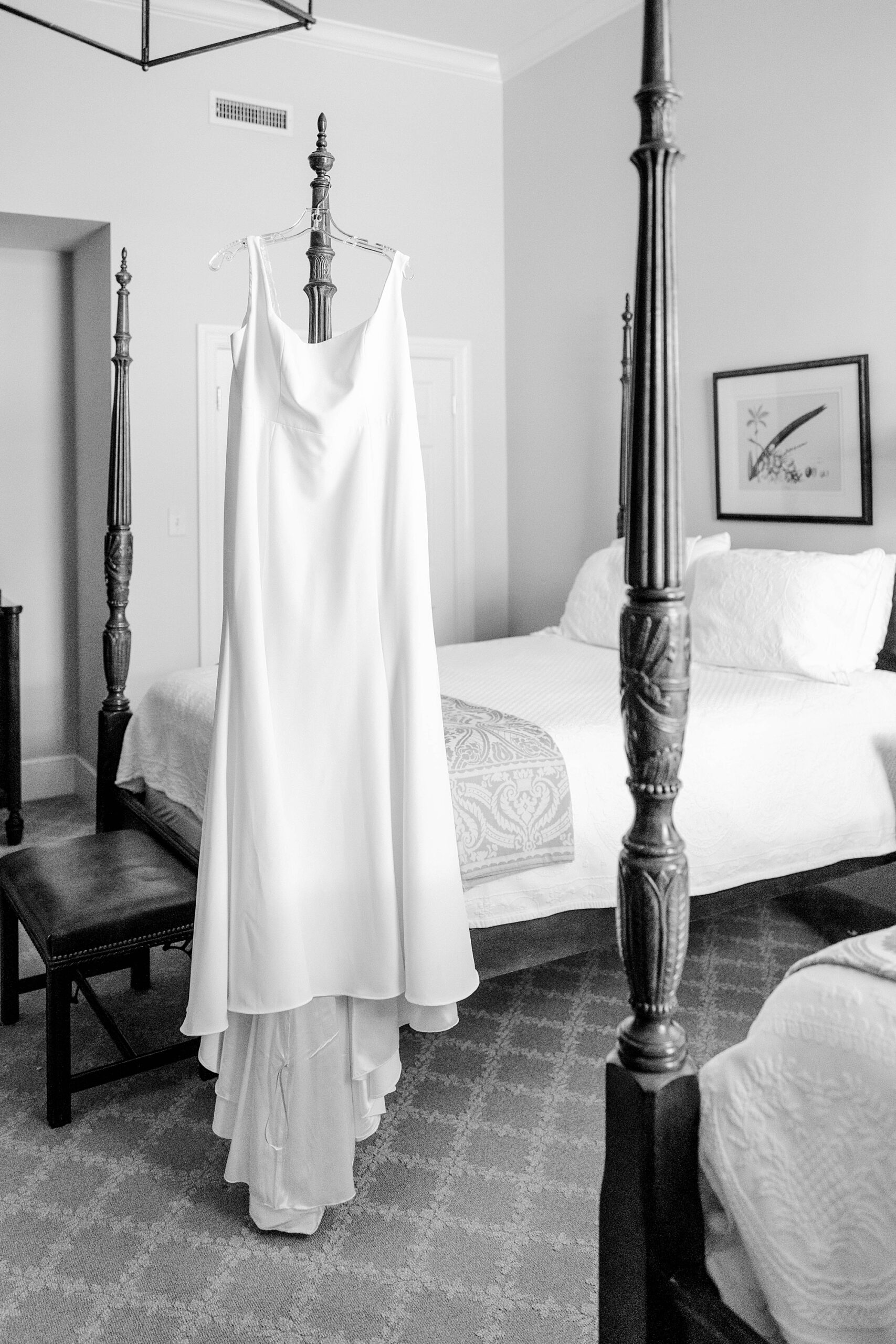 bride's wedding dress hangs on four poster bed at Planter's Inn