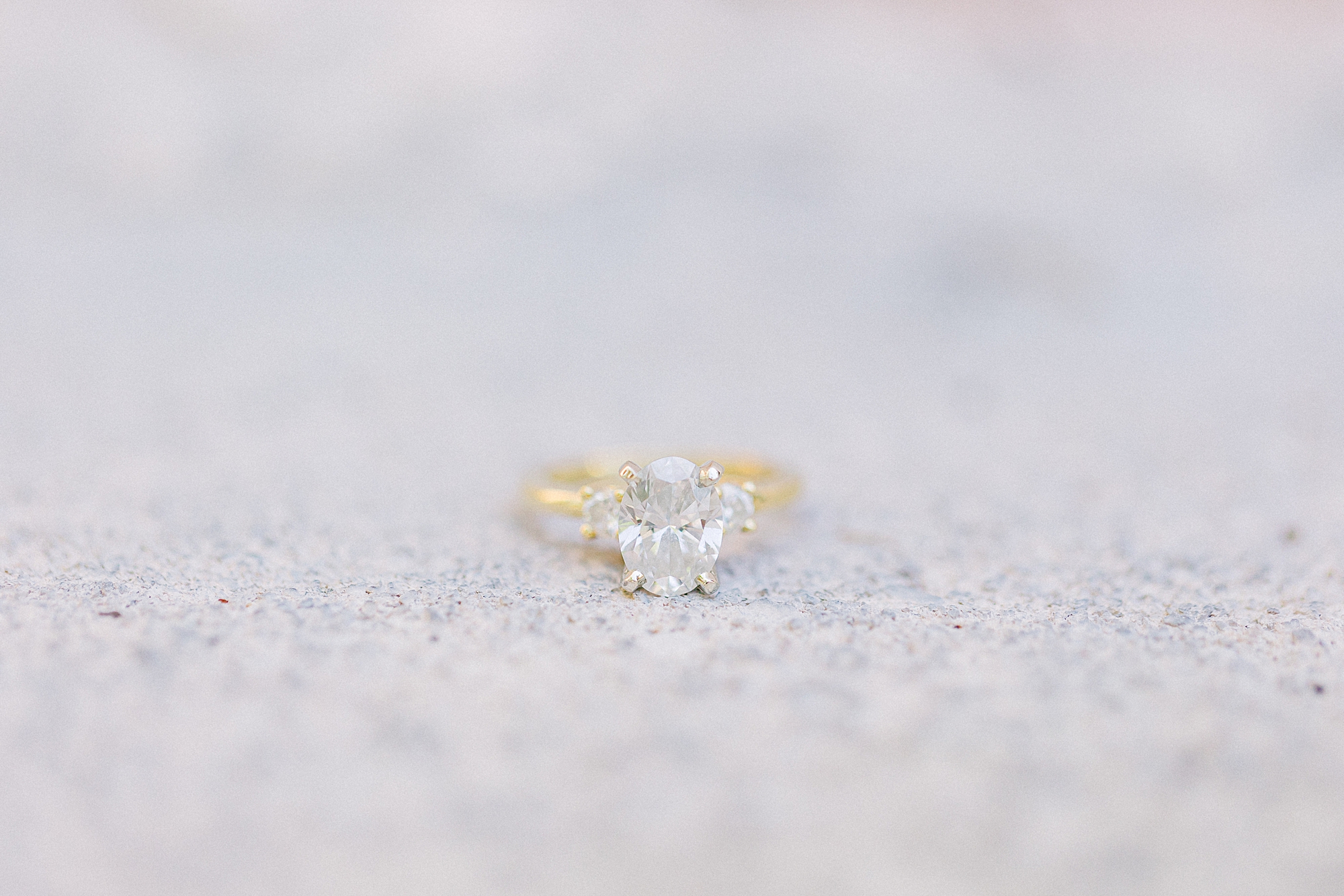 diamond ring with gold band lays on Charleston cobblestone