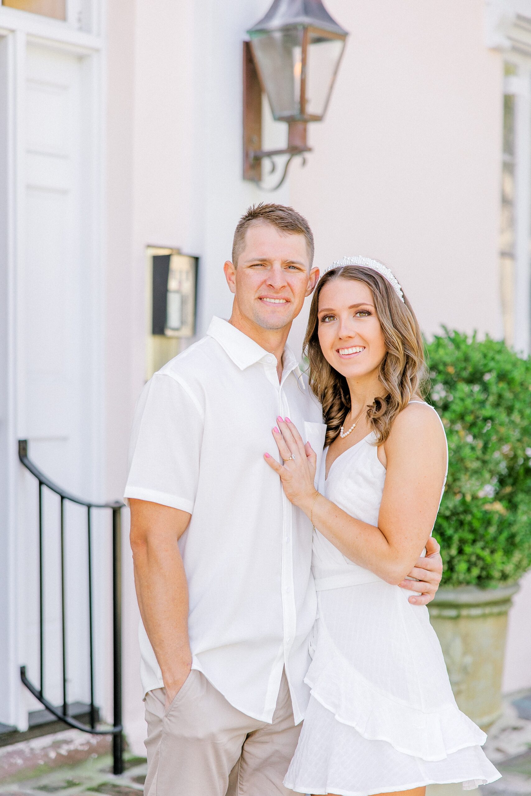 woman smiles leaning into man's shoulder during Historic Downtown Charleston engagement session