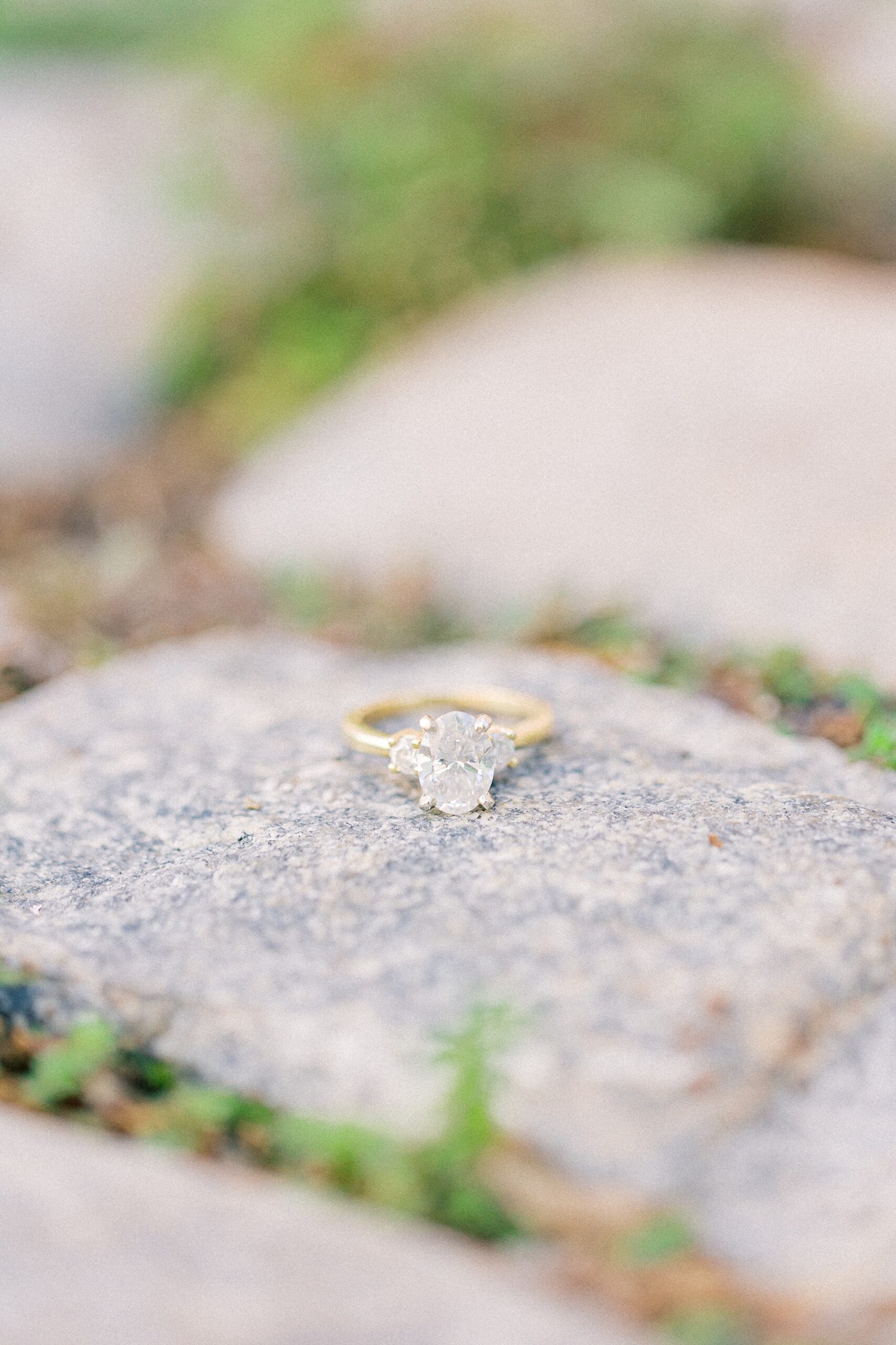 diamond and gold engagement ring on stone street