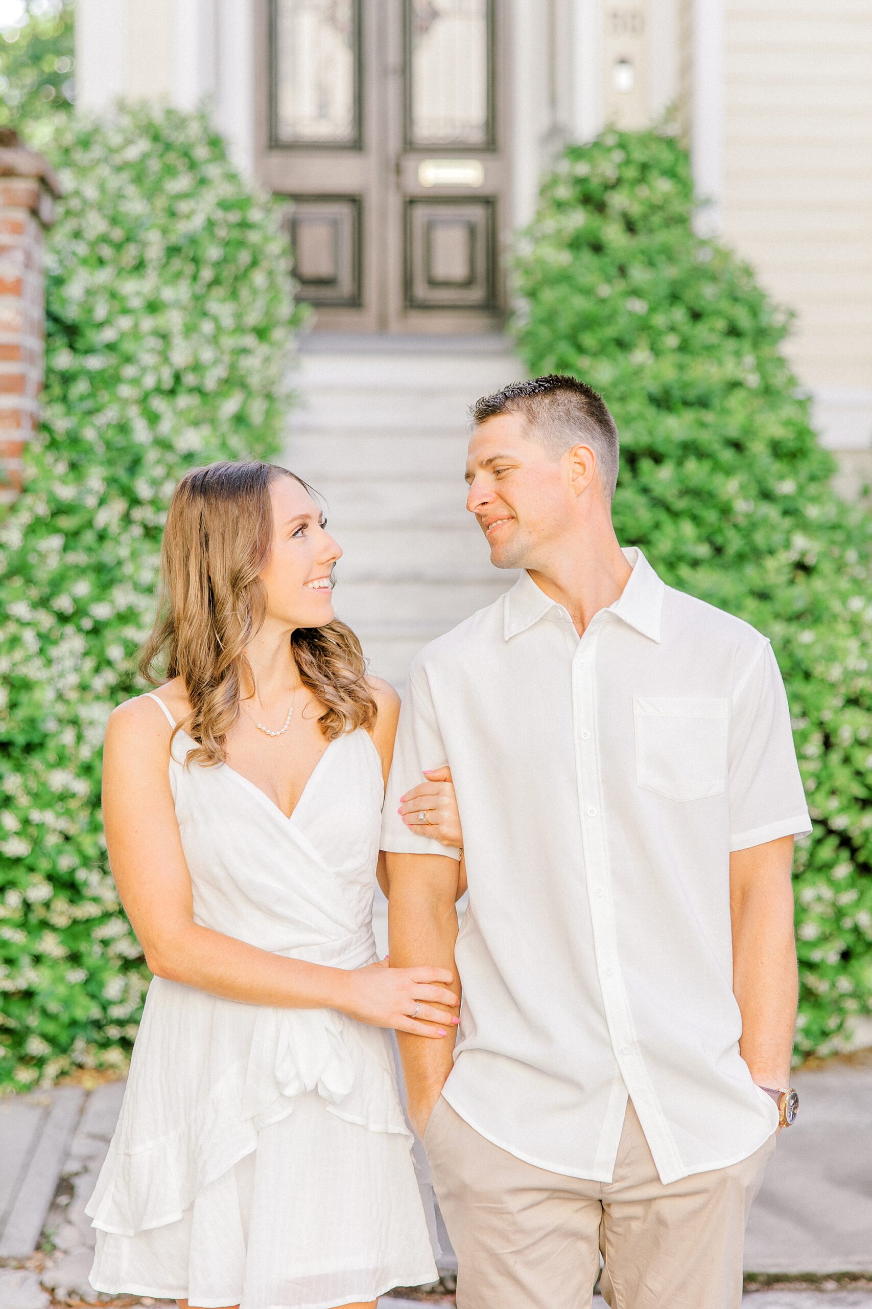 couple holds hands smiling together during Historic Downtown Charleston engagement session