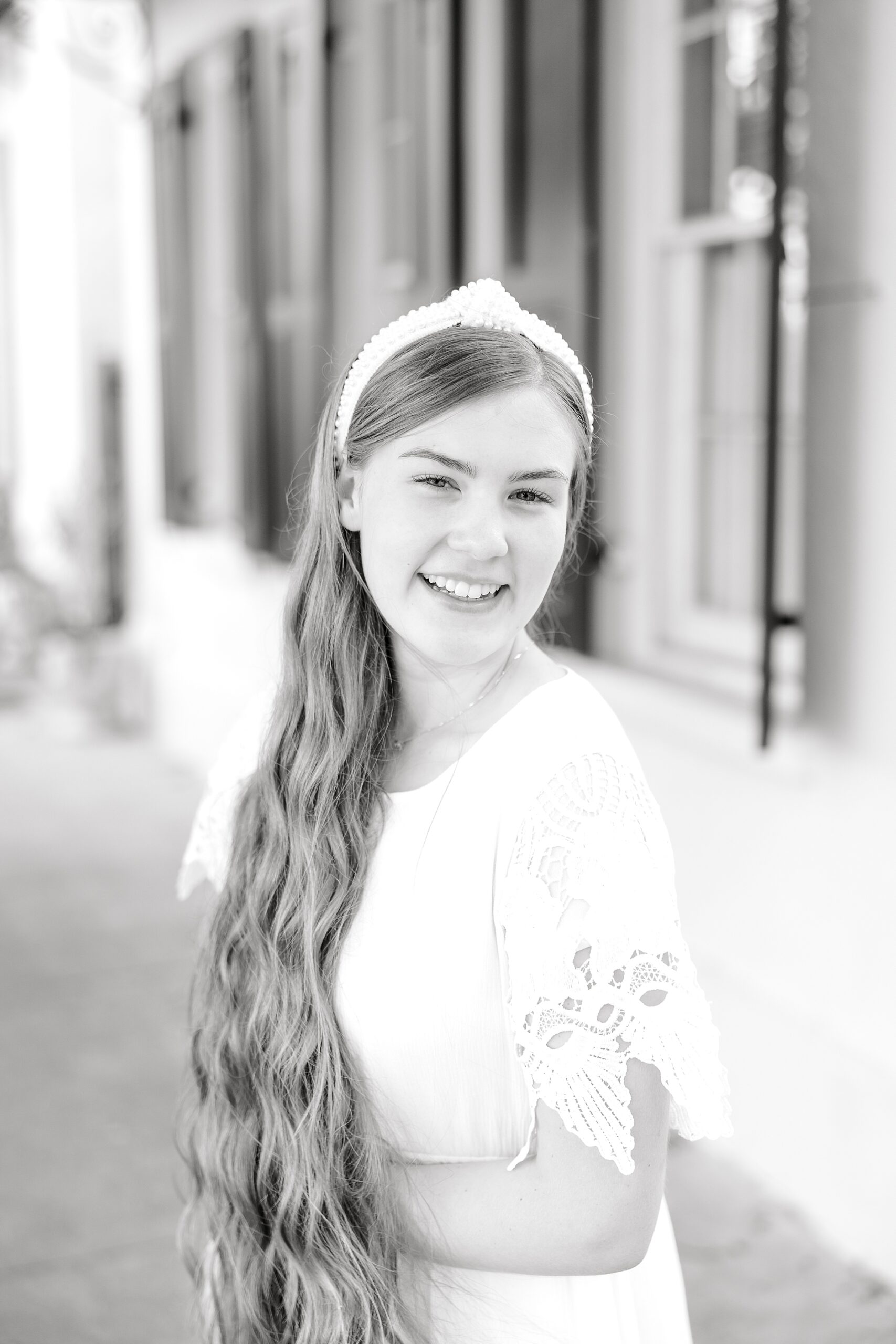 girl smiles leaning forward during senior portraits in Charleston SC