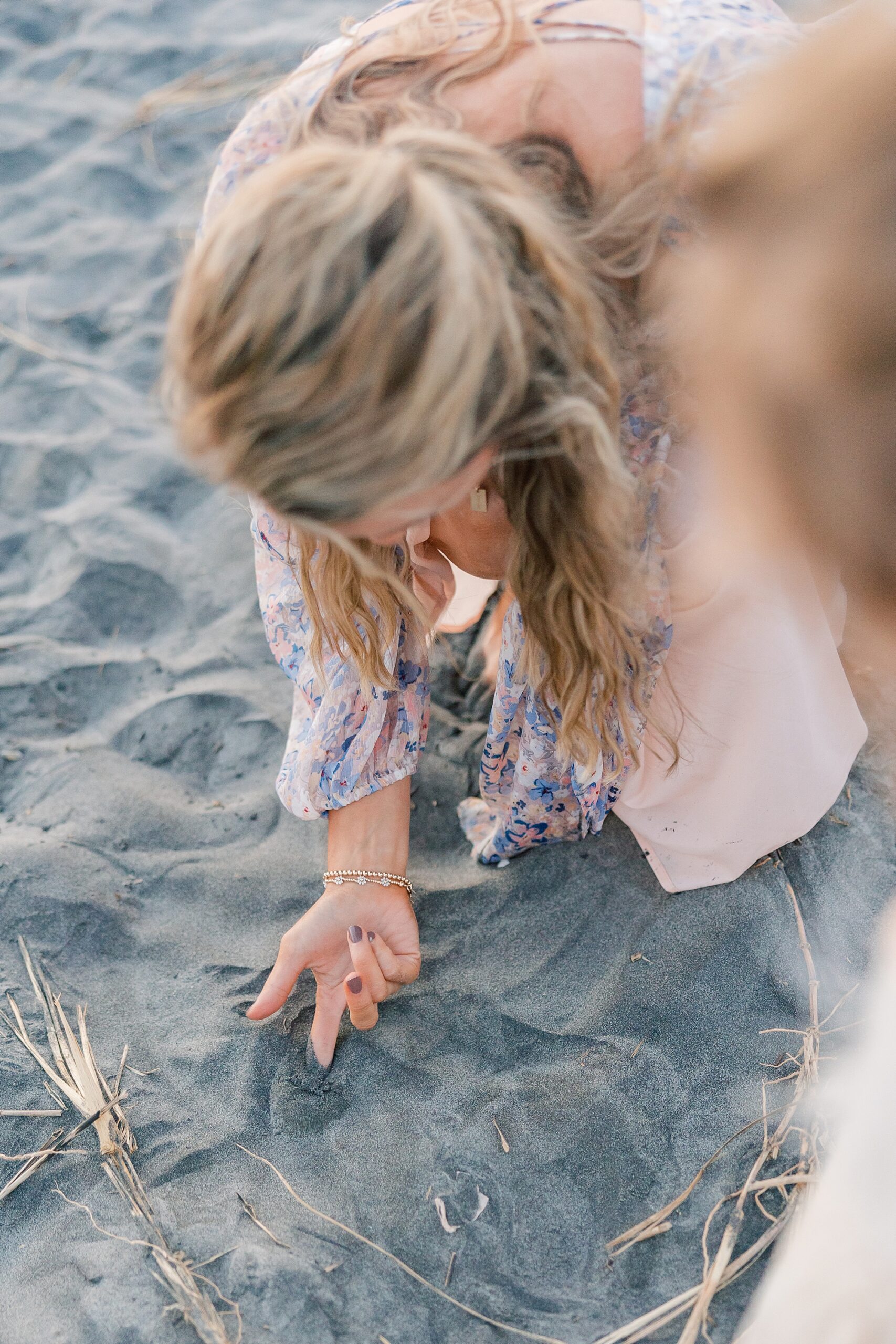 mom points at crab in the sand during Folly Beach family portraits
