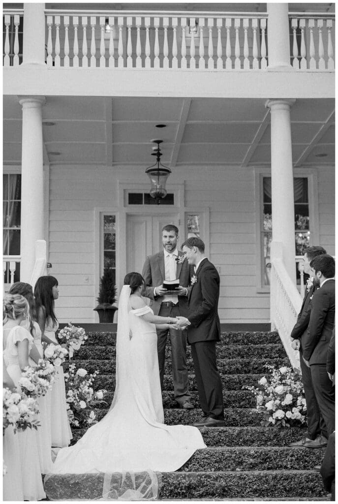 Bride and groom sharing their vows on the ivy staircase at Old Wide Awake during their summer Charleston wedding.